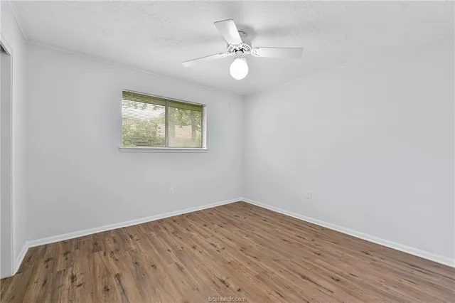 a view of a room with wooden floor and window