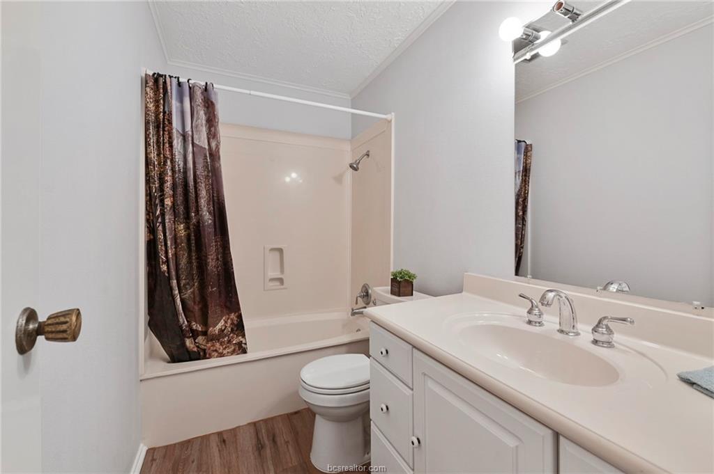 1031 Rose Circle College Station, TX 77840 - Photo 22 of 26 Bathroom with shower / tub combo, a textured ceiling, vanity, and light wood-style flooring