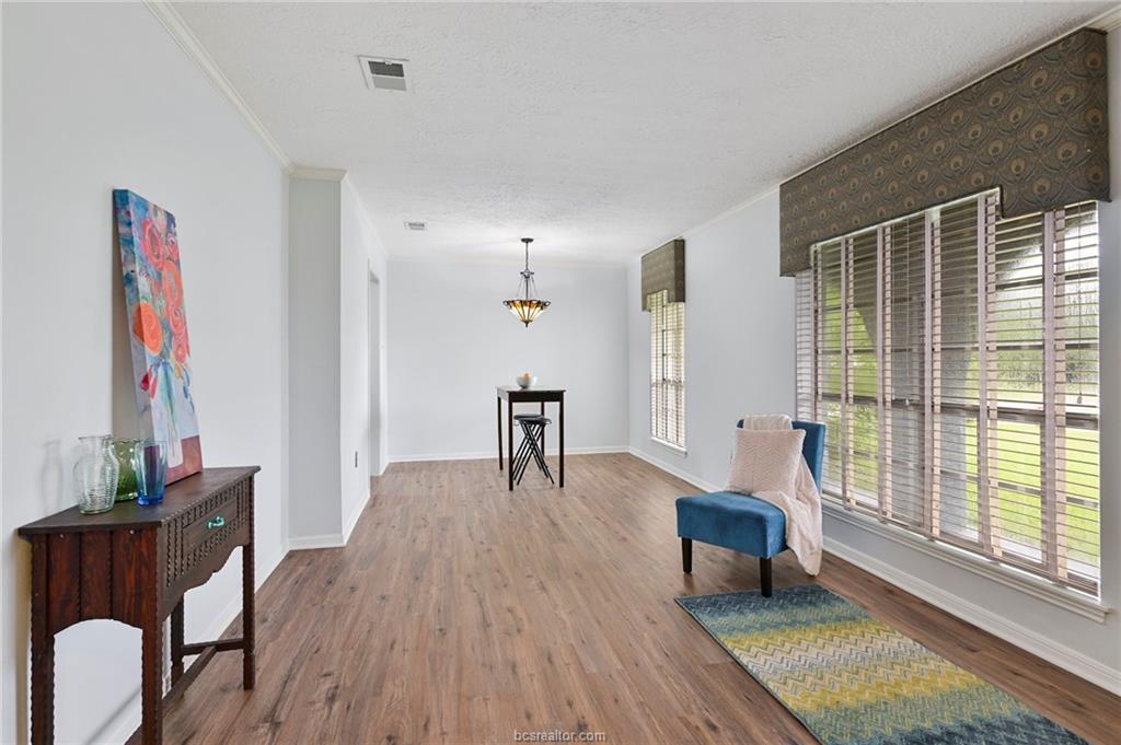 1031 Rose Circle College Station, TX 77840 - Photo 7 of 26 Sitting room with ornamental molding, wood finished floors, and a textured ceiling