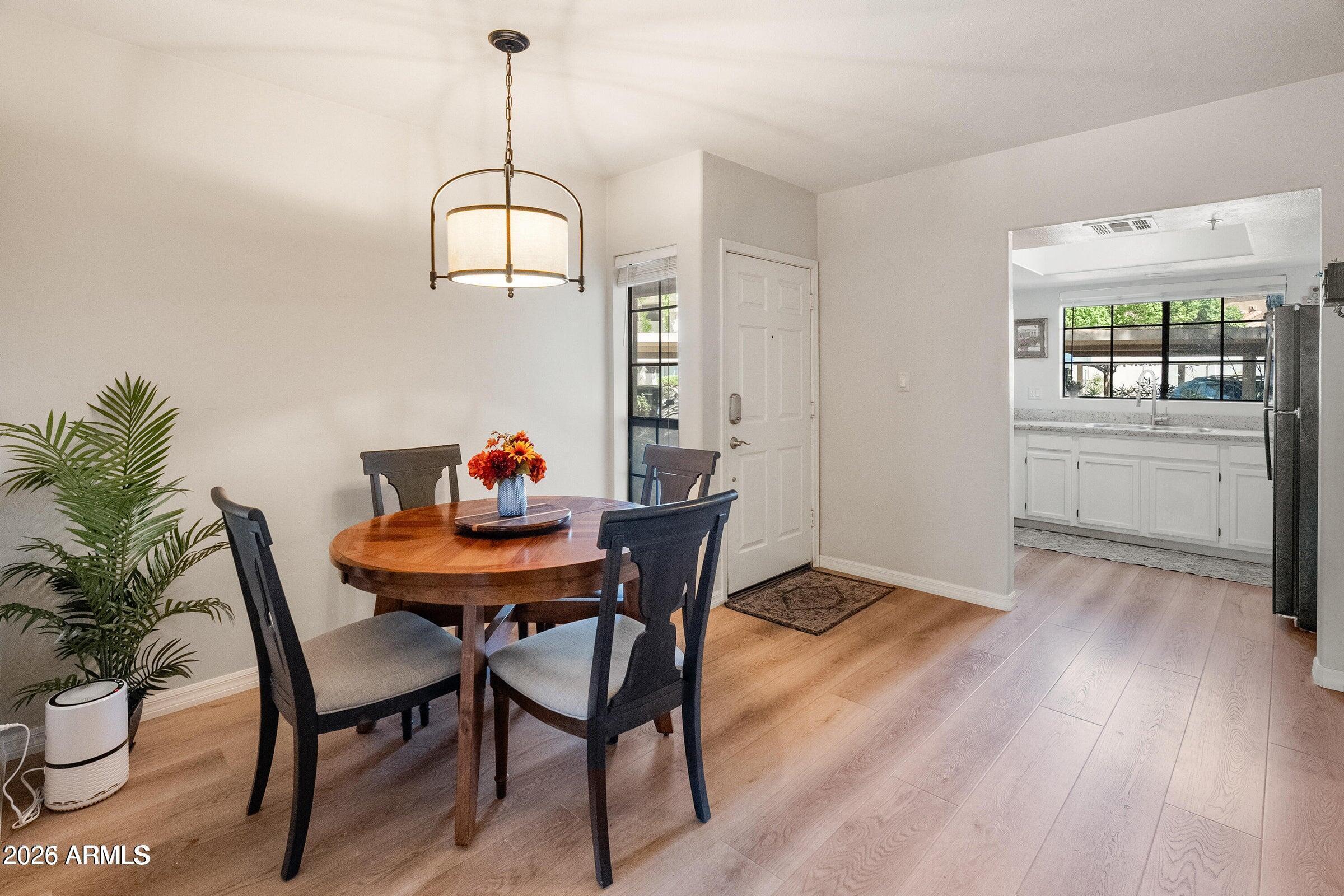 6885 East Cochise Road, Unit 132 Paradise Valley, AZ 85253 - Photo 3 of 10 a dining room with furniture potted plants and wooden floor