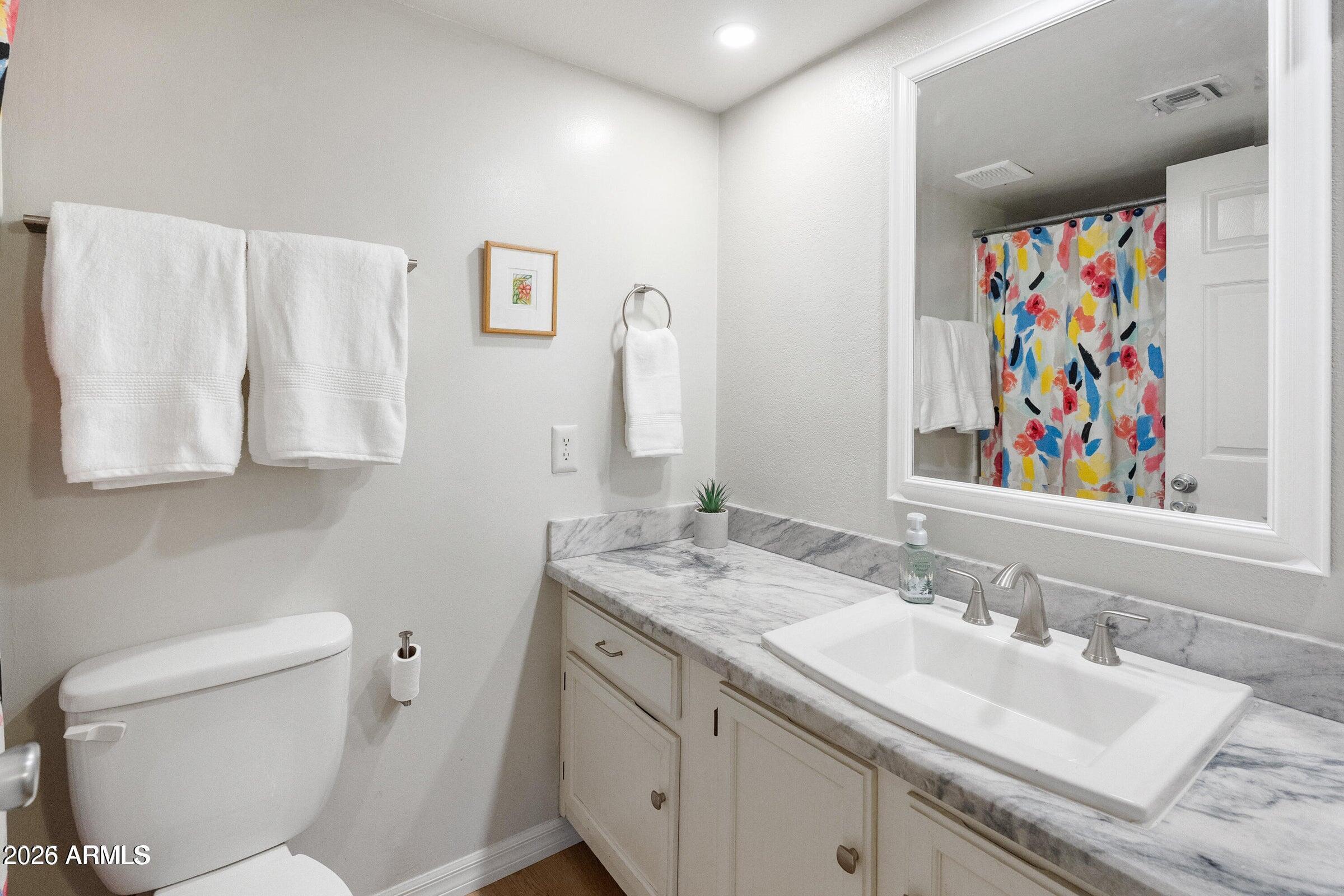 6885 East Cochise Road, Unit 132 Paradise Valley, AZ 85253 - Photo 6 of 10 a bathroom with a granite countertop sink mirror and vanity