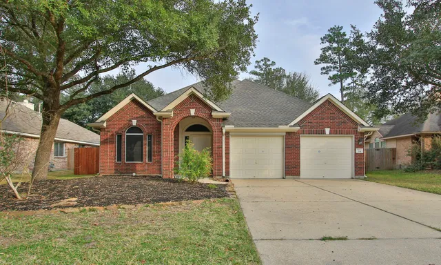 a front view of a house with yard and tree