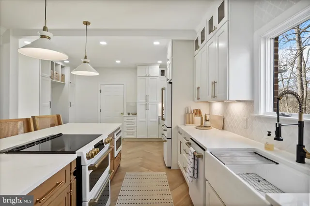 a large kitchen with stainless steel appliances granite countertop a stove a sink a dining table and chairs