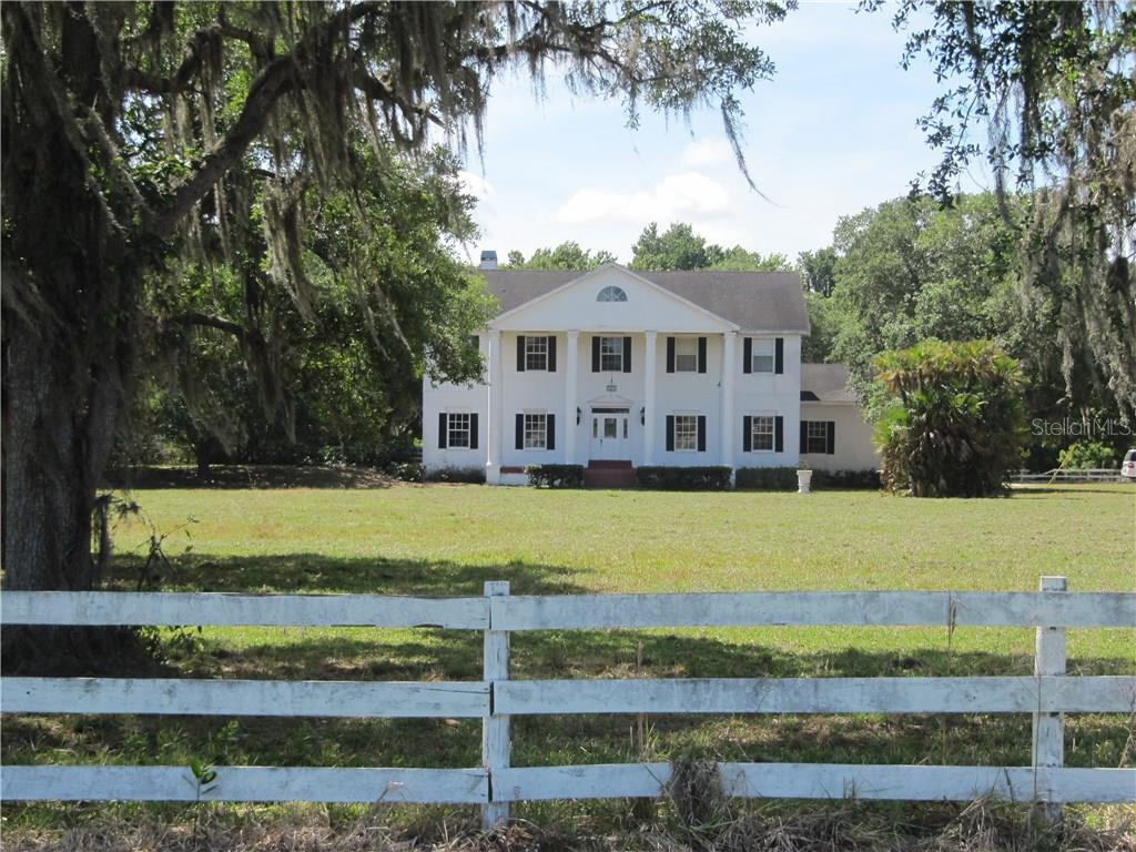 a view of a house with a swimming pool and a yard