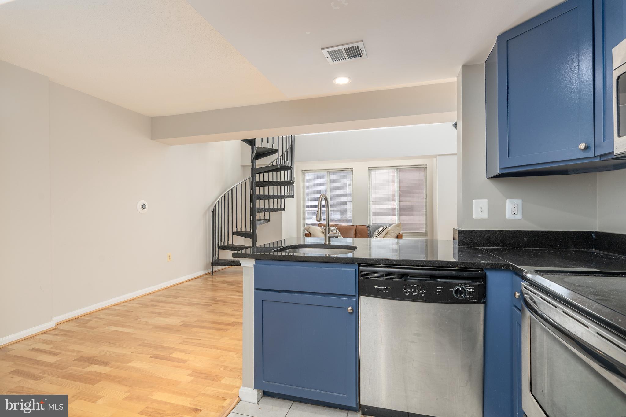 1225 13th Street Northwest, Unit 509 Washington, DC 20005 - Photo 12 of 29 a kitchen with kitchen island granite countertop a sink cabinets and stainless steel appliances
