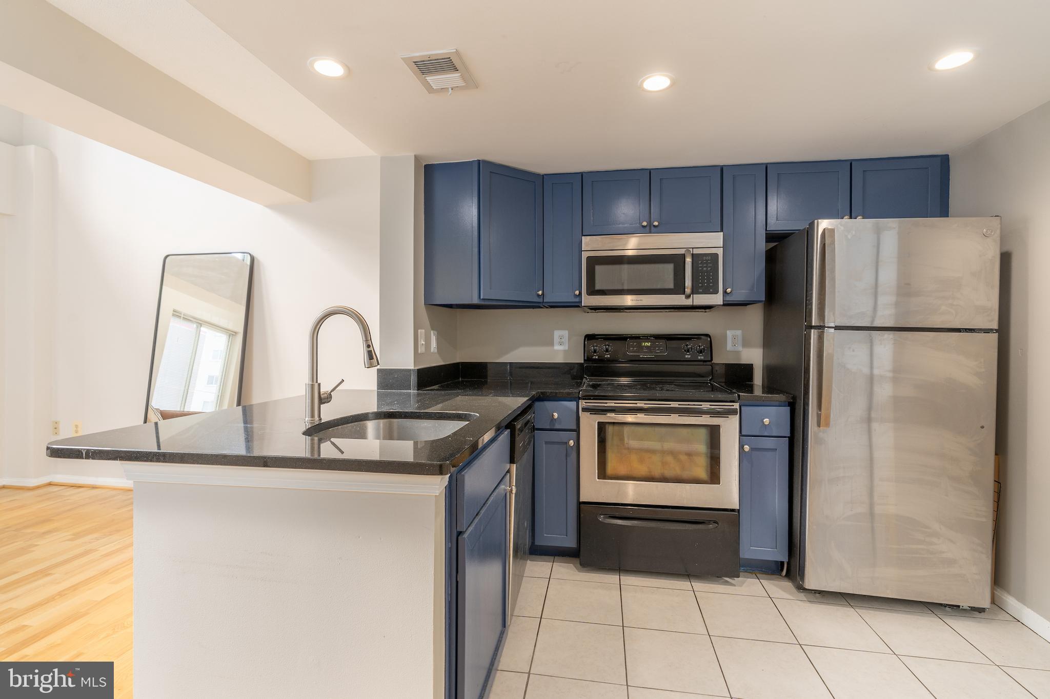 1225 13th Street Northwest, Unit 509 Washington, DC 20005 - Photo 10 of 29 a kitchen with kitchen island a counter top space cabinets and stainless steel appliances