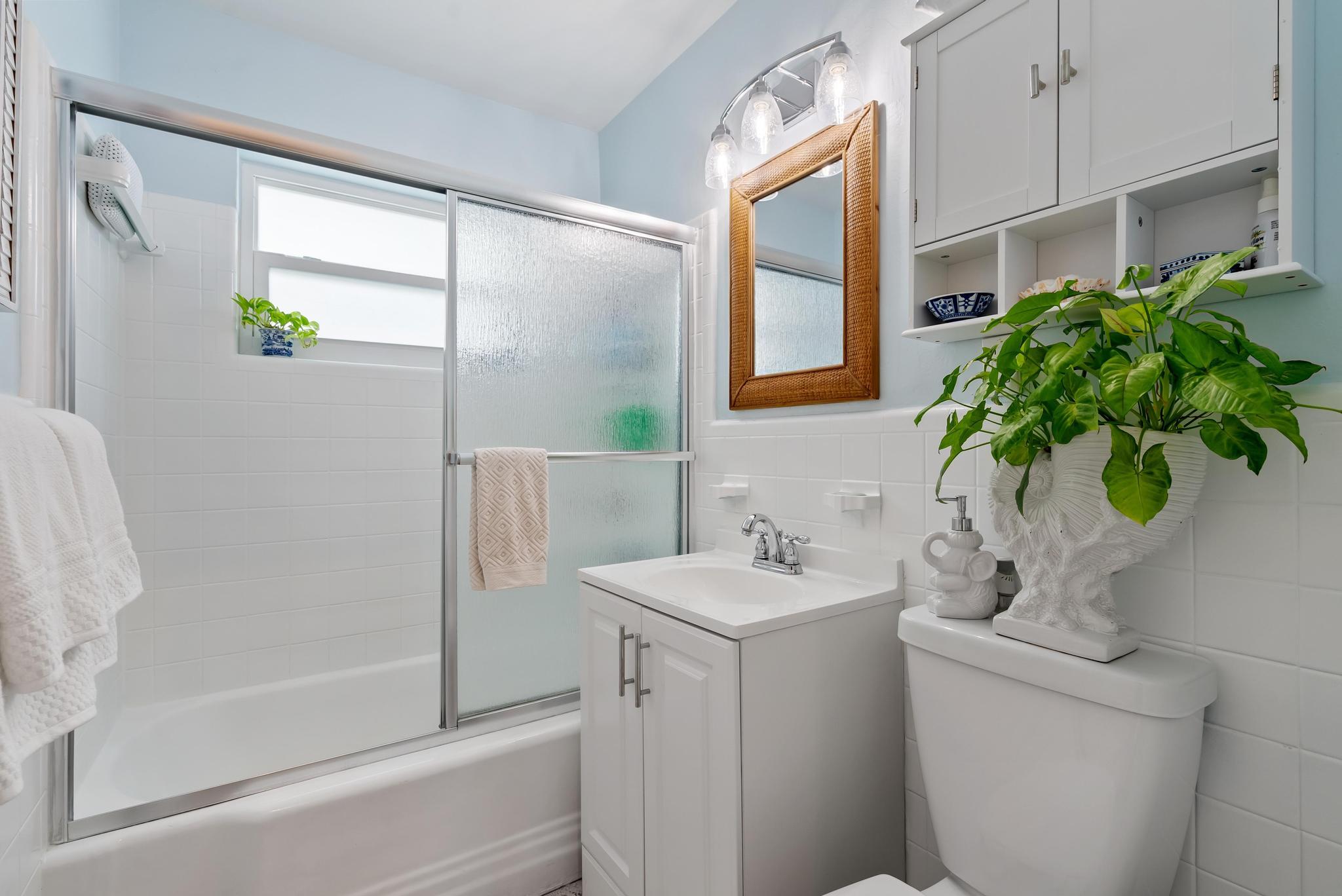 2122 Northridge Road Delray Beach, FL 33444 - Photo 28 of 39 a bathroom with a shower curtain a mirror and a sink