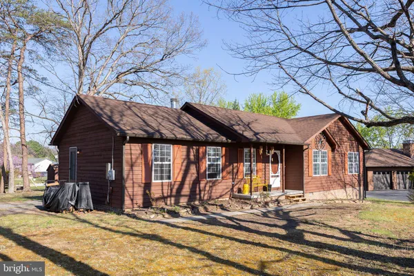 a view of a house with snow on the wall and a tree