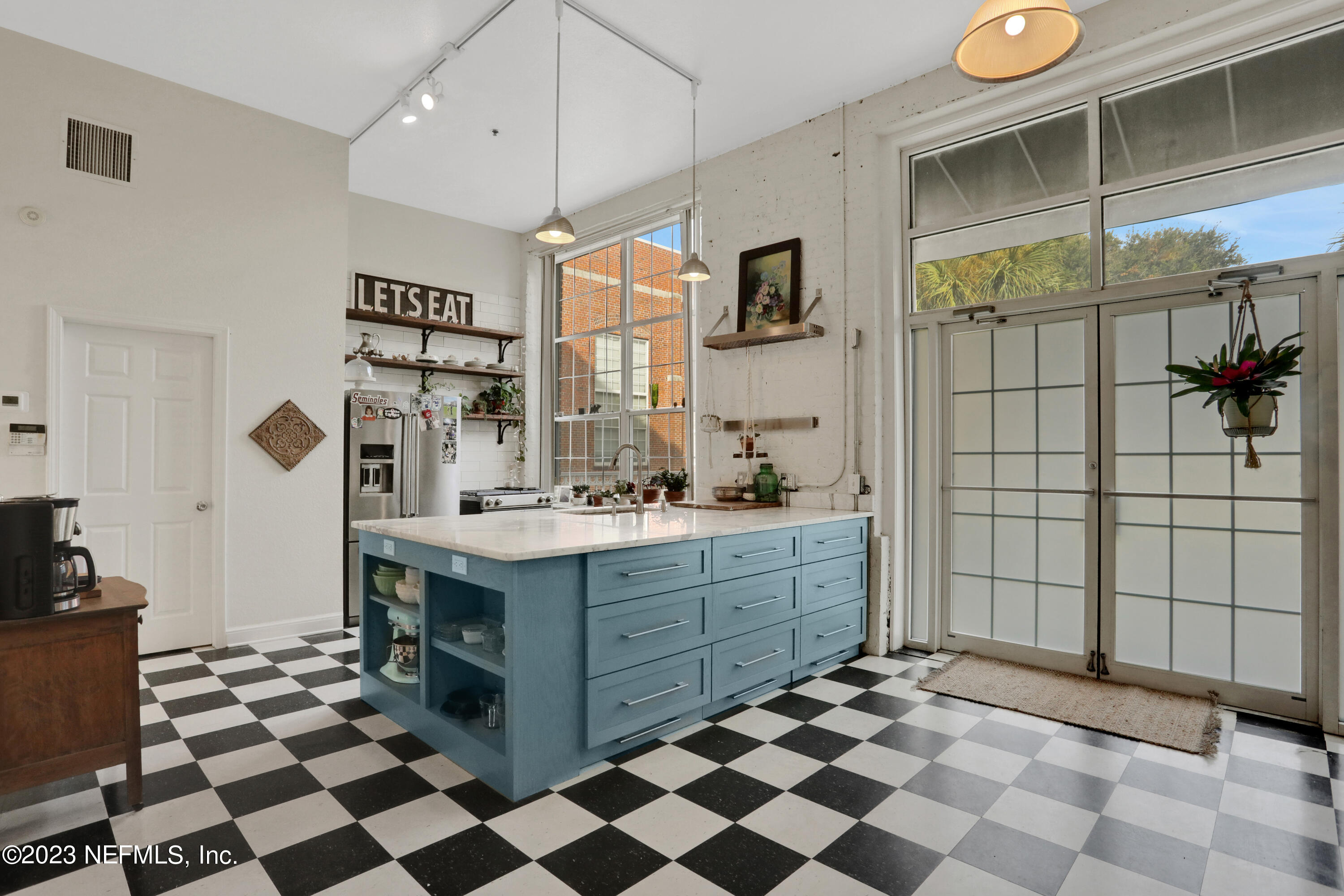 a kitchen with a checkered floor and white cabinets