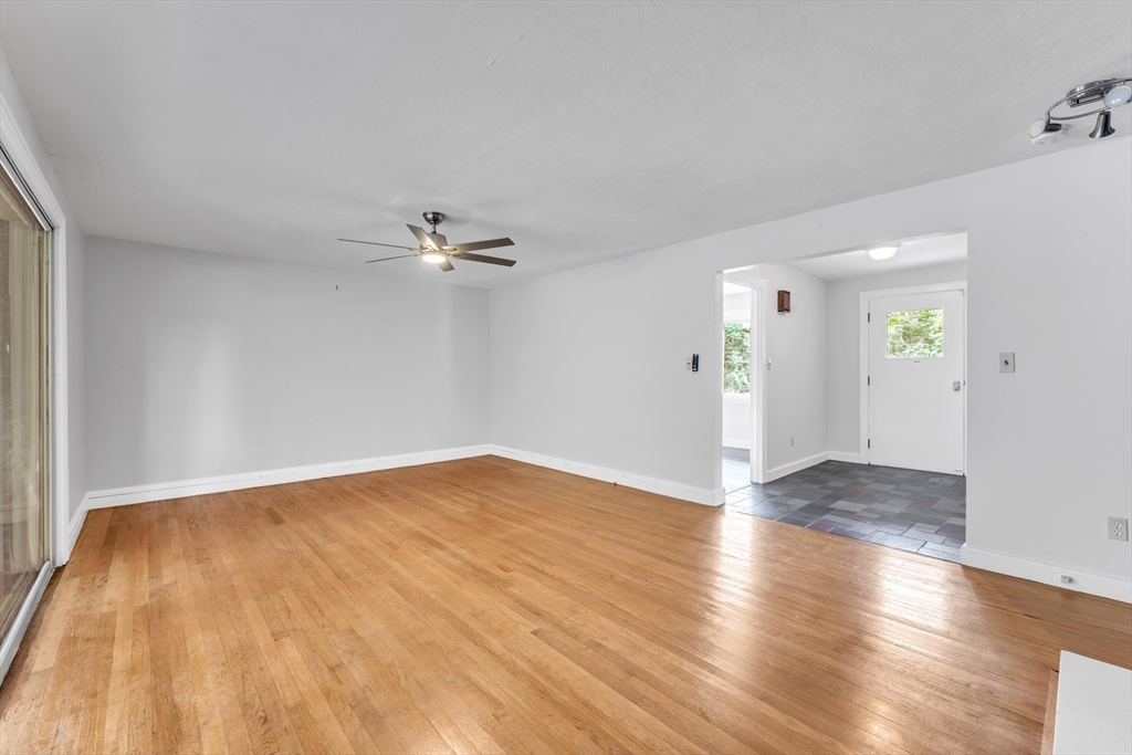 1127 East Street North Suffield, CT 06078 - Photo 17 of 40 an empty room with wooden floor ceiling fan and windows