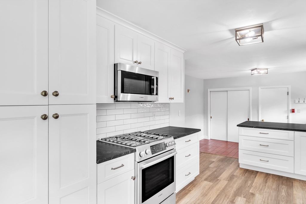 1127 East Street North Suffield, CT 06078 - Photo 7 of 40 a kitchen with cabinets appliances and a wooden floor