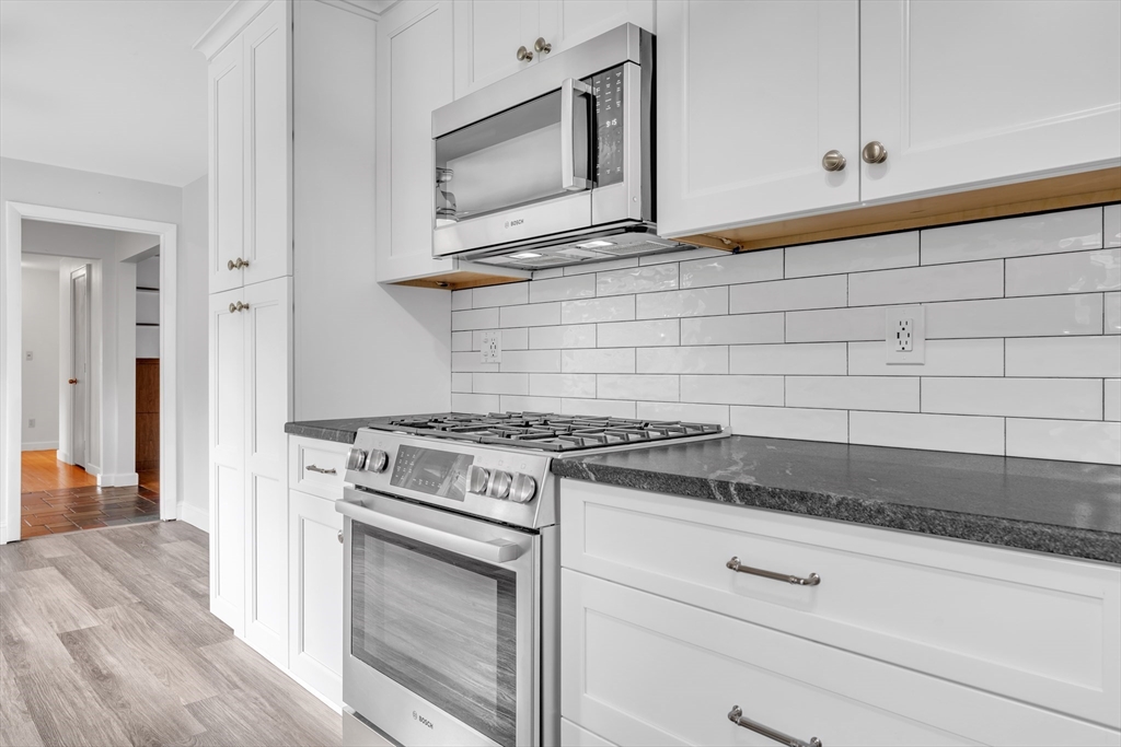 1127 East Street North Suffield, CT 06078 - Photo 8 of 40 a kitchen with granite countertop cabinets stainless steel appliances and wooden floor