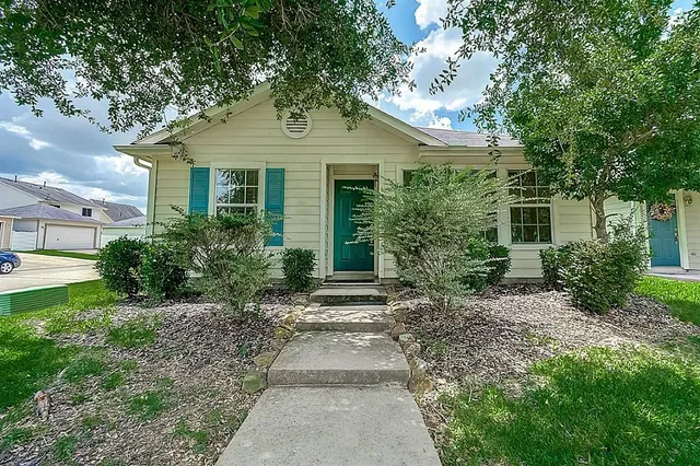 a front view of a house with a yard and trees