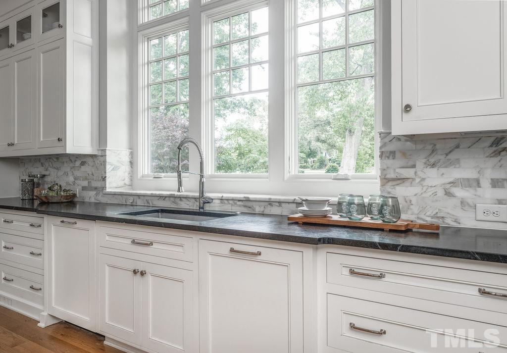 4427 Laurel Hills Road Raleigh, NC 27612 - Photo 21 of 89 a kitchen with granite countertop white cabinets and a window