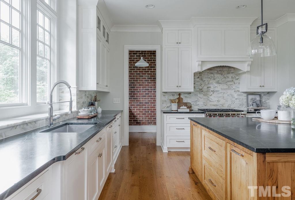 4427 Laurel Hills Road Raleigh, NC 27612 - Photo 23 of 89 a kitchen with granite countertop a sink stove and cabinets