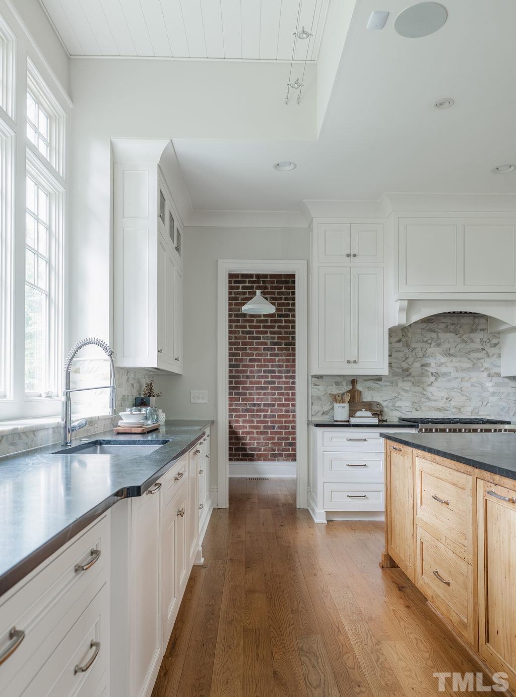 4427 Laurel Hills Road Raleigh, NC 27612 - Photo 25 of 89 a kitchen with granite countertop a sink stove and cabinets