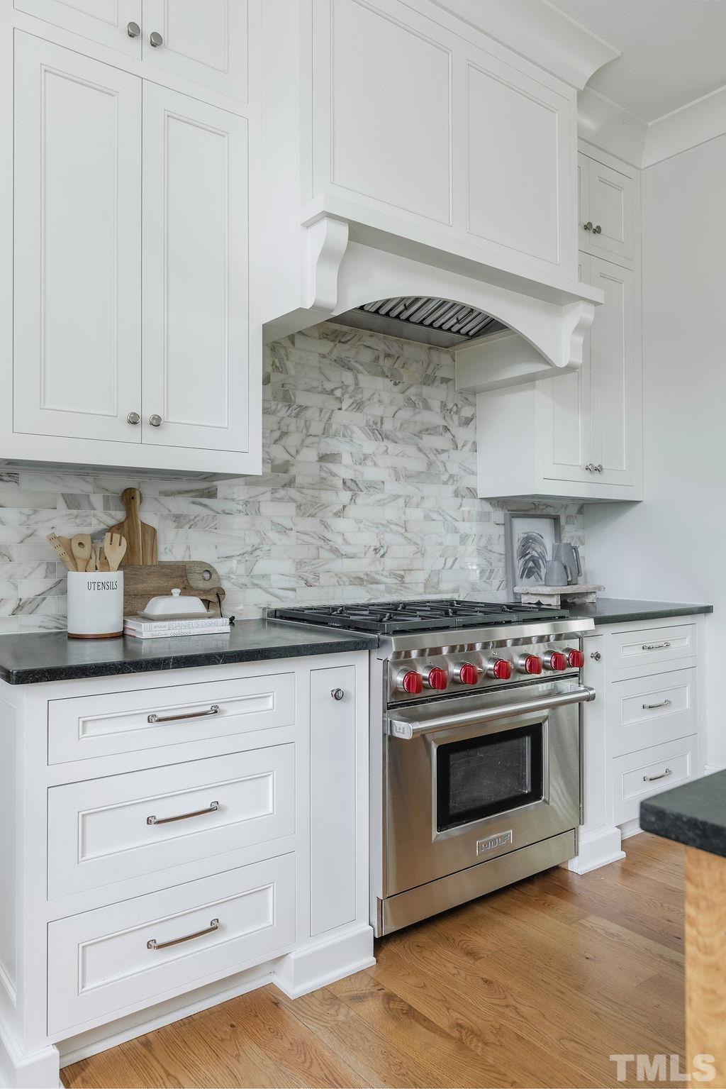 4427 Laurel Hills Road Raleigh, NC 27612 - Photo 28 of 89 a kitchen with granite countertop white cabinets and stainless steel appliances