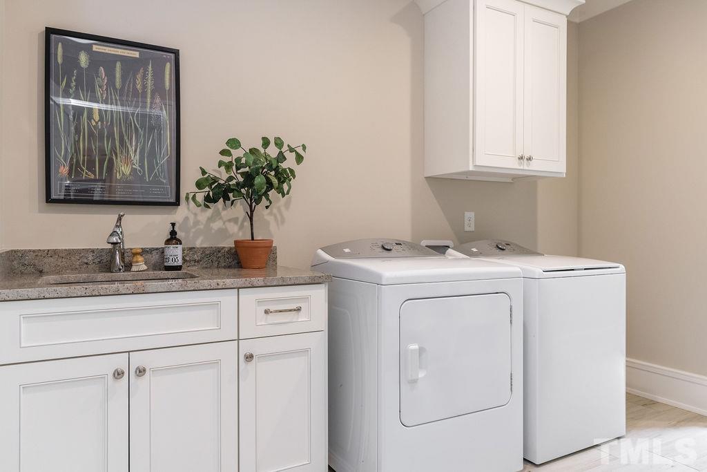 4427 Laurel Hills Road Raleigh, NC 27612 - Photo 64 of 89 a utility room with cabinets washer and dryer