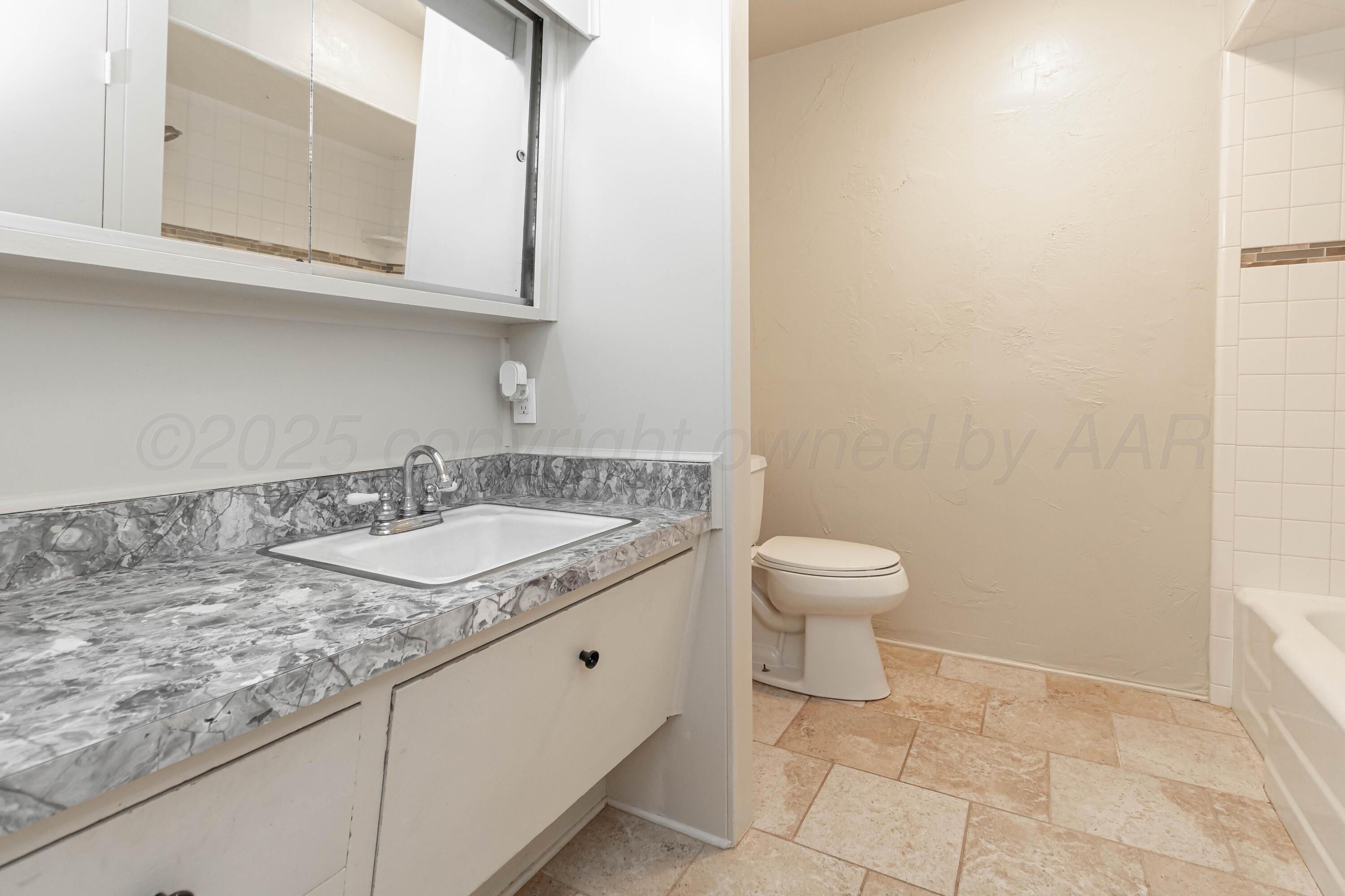 5207 Tumbleweed Drive Amarillo, TX 79110 - Photo 13 of 19 a bathroom with a granite countertop sink and a toilet