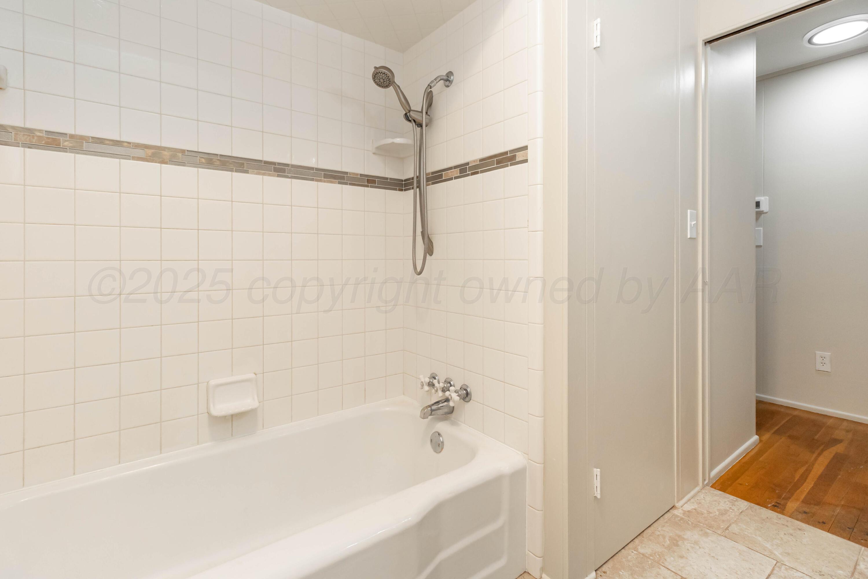 5207 Tumbleweed Drive Amarillo, TX 79110 - Photo 14 of 19 a bathroom with a bathtub and a shower