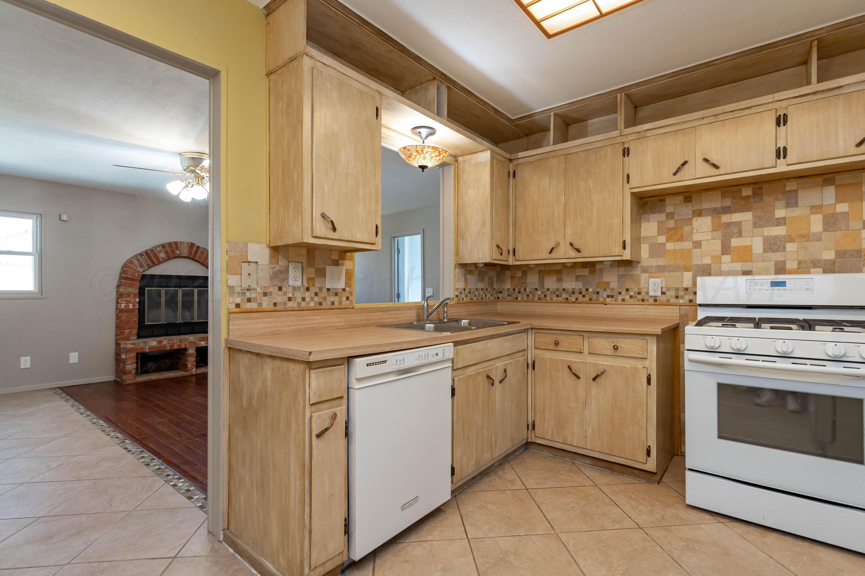 5207 Tumbleweed Drive Amarillo, TX 79110 - Photo 6 of 19 a kitchen with a stove sink and cabinets