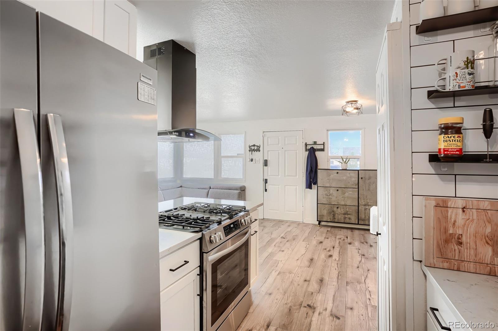 6461 Porter Way Commerce City, CO 80022 - Photo 11 of 23 a kitchen with stainless steel appliances granite countertop a refrigerator and a stove top oven