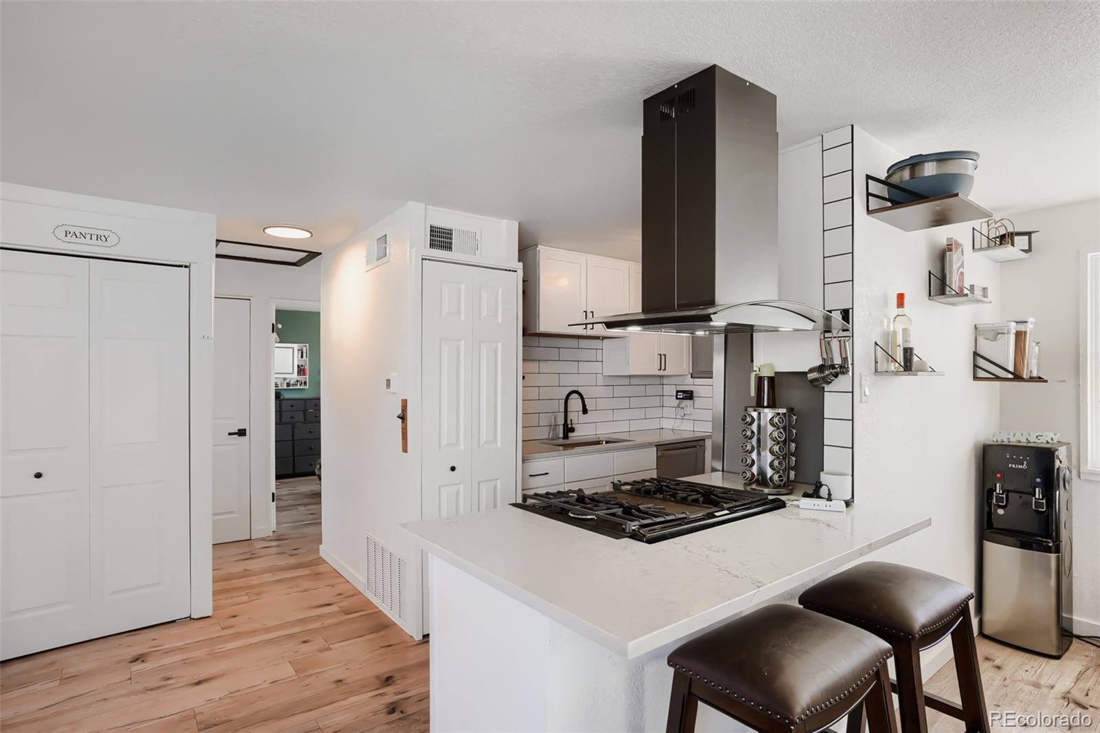 6461 Porter Way Commerce City, CO 80022 - Photo 12 of 23 a kitchen with stainless steel appliances a stove a refrigerator and wooden floor