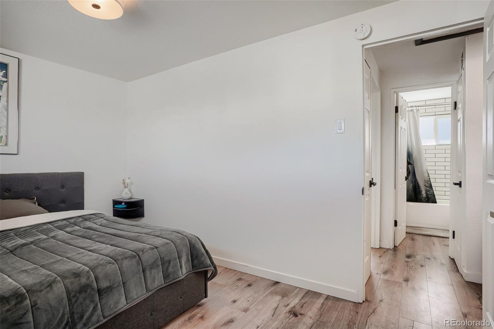 6461 Porter Way Commerce City, CO 80022 - Photo 15 of 23 a bedroom with a bed and wooden floor