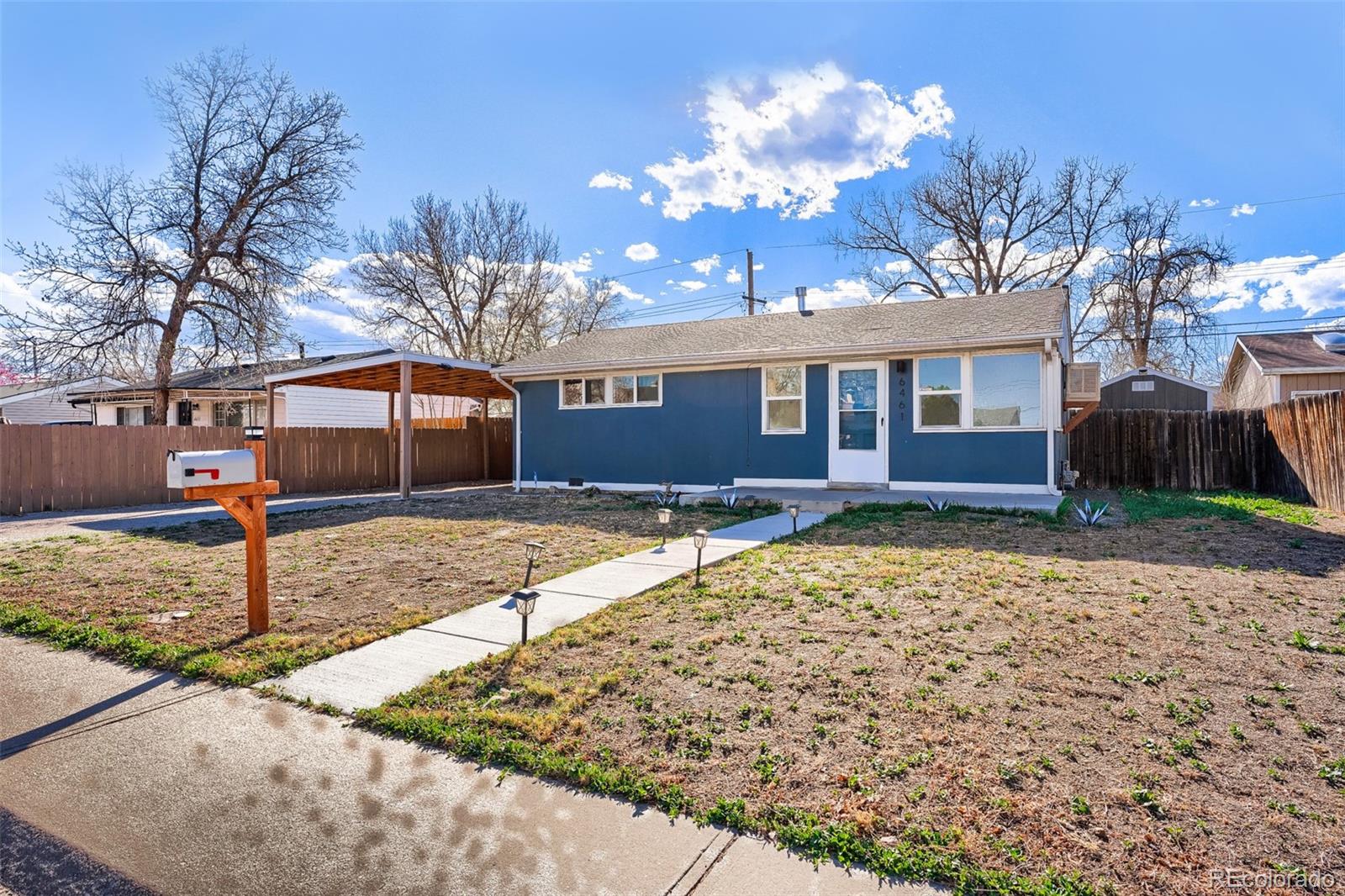 6461 Porter Way Commerce City, CO 80022 - Photo 2 of 23 a front view of a house with a yard