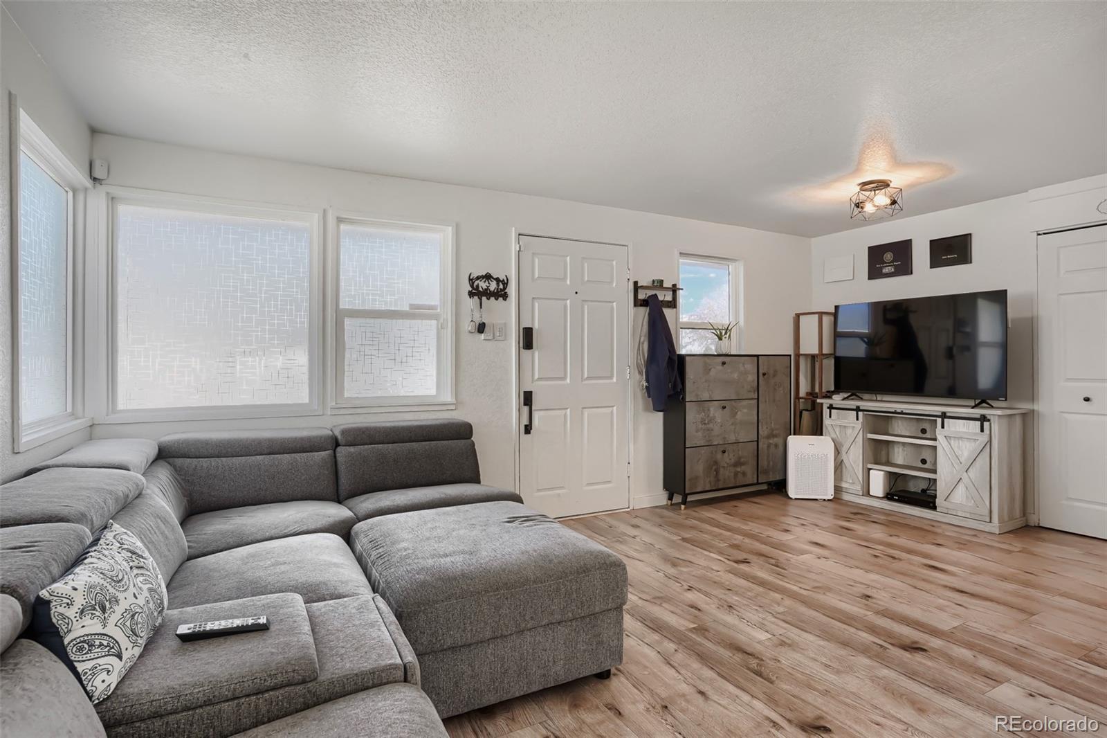 6461 Porter Way Commerce City, CO 80022 - Photo 3 of 23 a living room with furniture and a flat screen tv