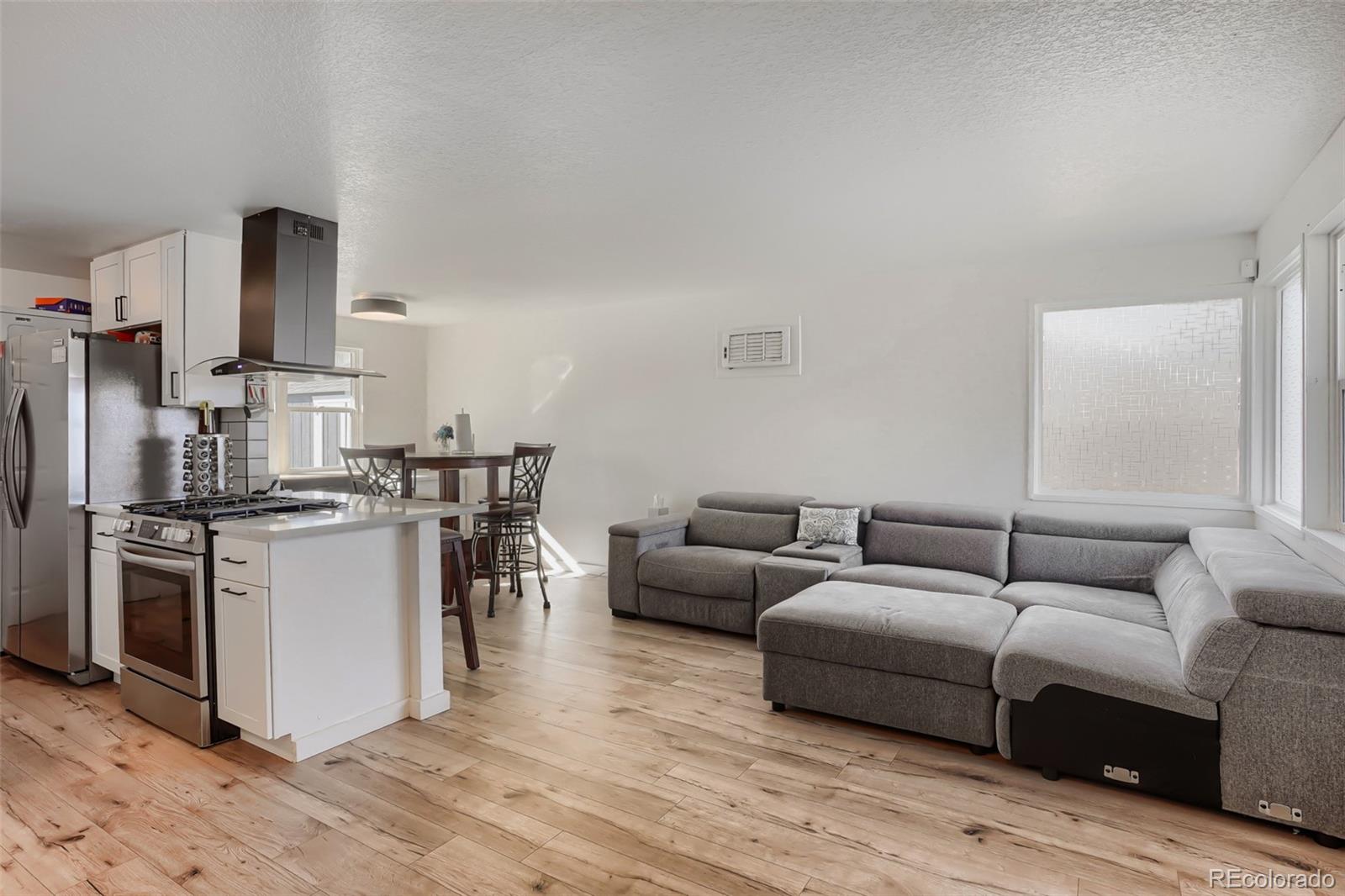 6461 Porter Way Commerce City, CO 80022 - Photo 6 of 23 a living room with furniture and a wooden floor