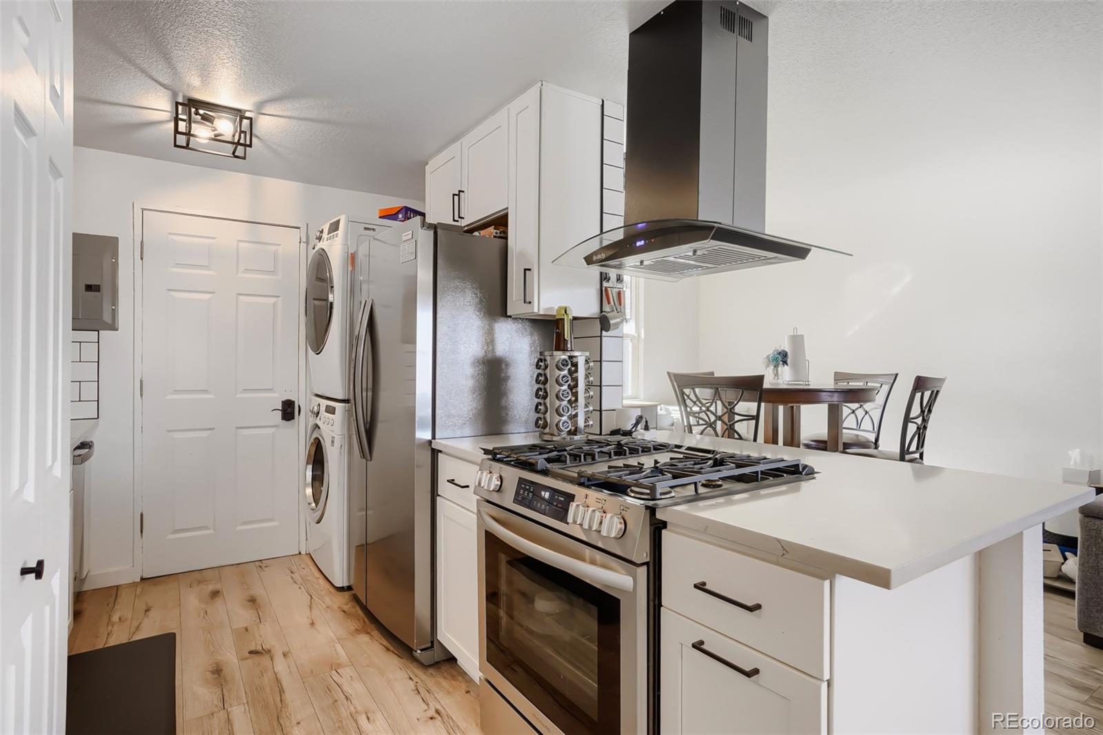6461 Porter Way Commerce City, CO 80022 - Photo 8 of 23 a kitchen with stainless steel appliances a stove a refrigerator and cabinets