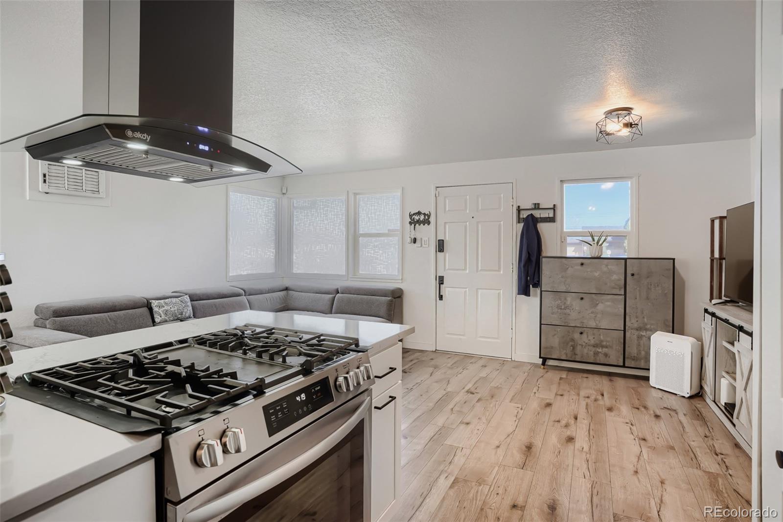 6461 Porter Way Commerce City, CO 80022 - Photo 10 of 23 a kitchen with a stove and a wooden floor