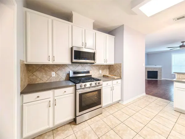 a kitchen with granite countertop white cabinets and appliances