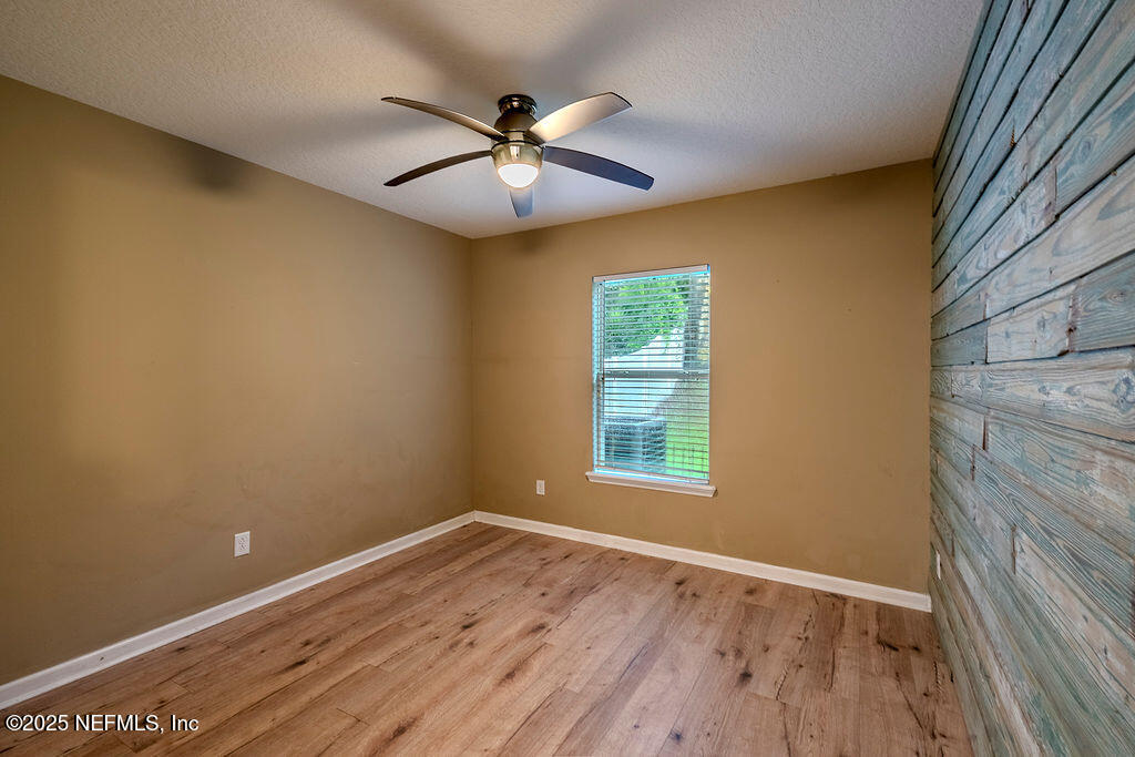 348 Auburn Oaks Road East Jacksonville, FL 32218 - Photo 12 of 30 an empty room with wooden floor fan and windows