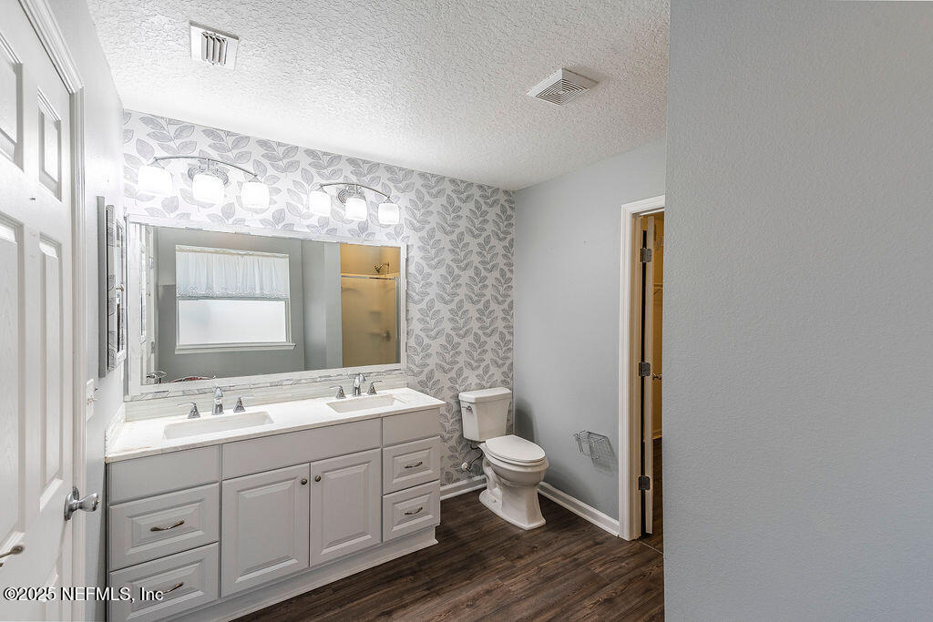 348 Auburn Oaks Road East Jacksonville, FL 32218 - Photo 17 of 30 a spacious bathroom with a double vanity sink a mirror and a toilet