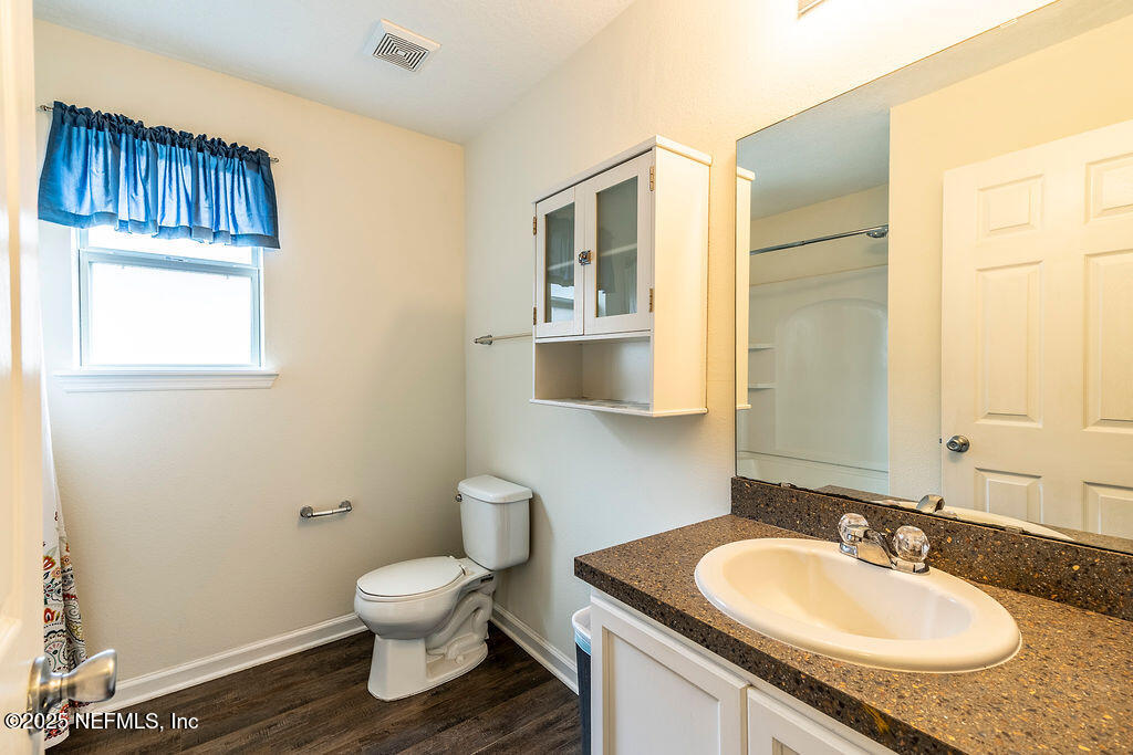 348 Auburn Oaks Road East Jacksonville, FL 32218 - Photo 25 of 30 a bathroom with a granite countertop sink a toilet and a mirror