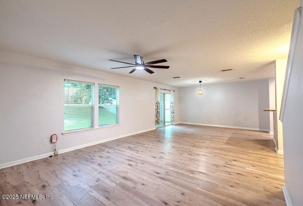 348 Auburn Oaks Road East Jacksonville, FL 32218 - Photo 9 of 30 a view of an empty room with wooden floor and a window