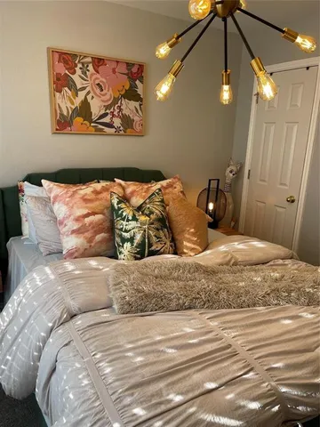 a bedroom with a large bed and a chandelier