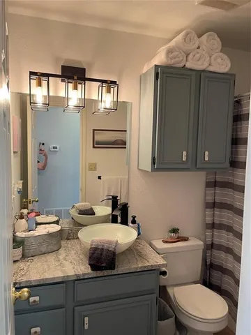 a bathroom with a granite countertop sink a mirror and shower