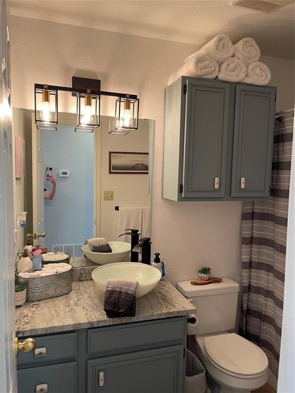 3063 Hells Gate Loop, Unit 23 Strawn, TX 76475 - Photo 13 of 36 a bathroom with a granite countertop toilet sink and mirror