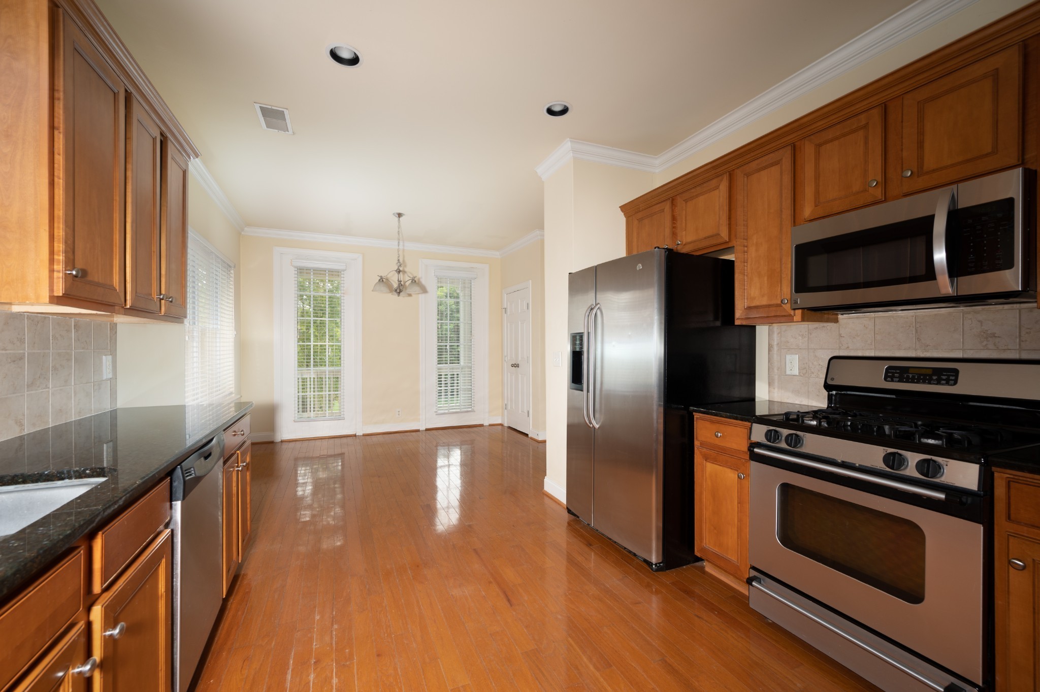 340 Wandering Circle Franklin, TN 37067 - Photo 21 of 51 a kitchen with stainless steel appliances wooden cabinets a stove a refrigerator and a microwave