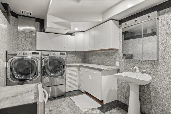 a utility room with sink dryer and washer