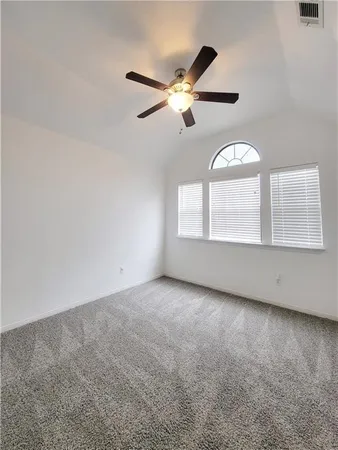 an empty room with windows and fan
