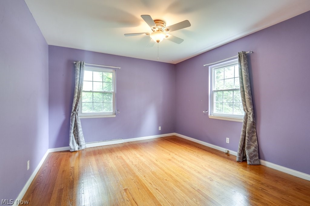 3060 Chamberlain Road Akron, OH 44333 - Photo 34 of 47 Empty room featuring baseboard heating, wood-type flooring, and ceiling fan