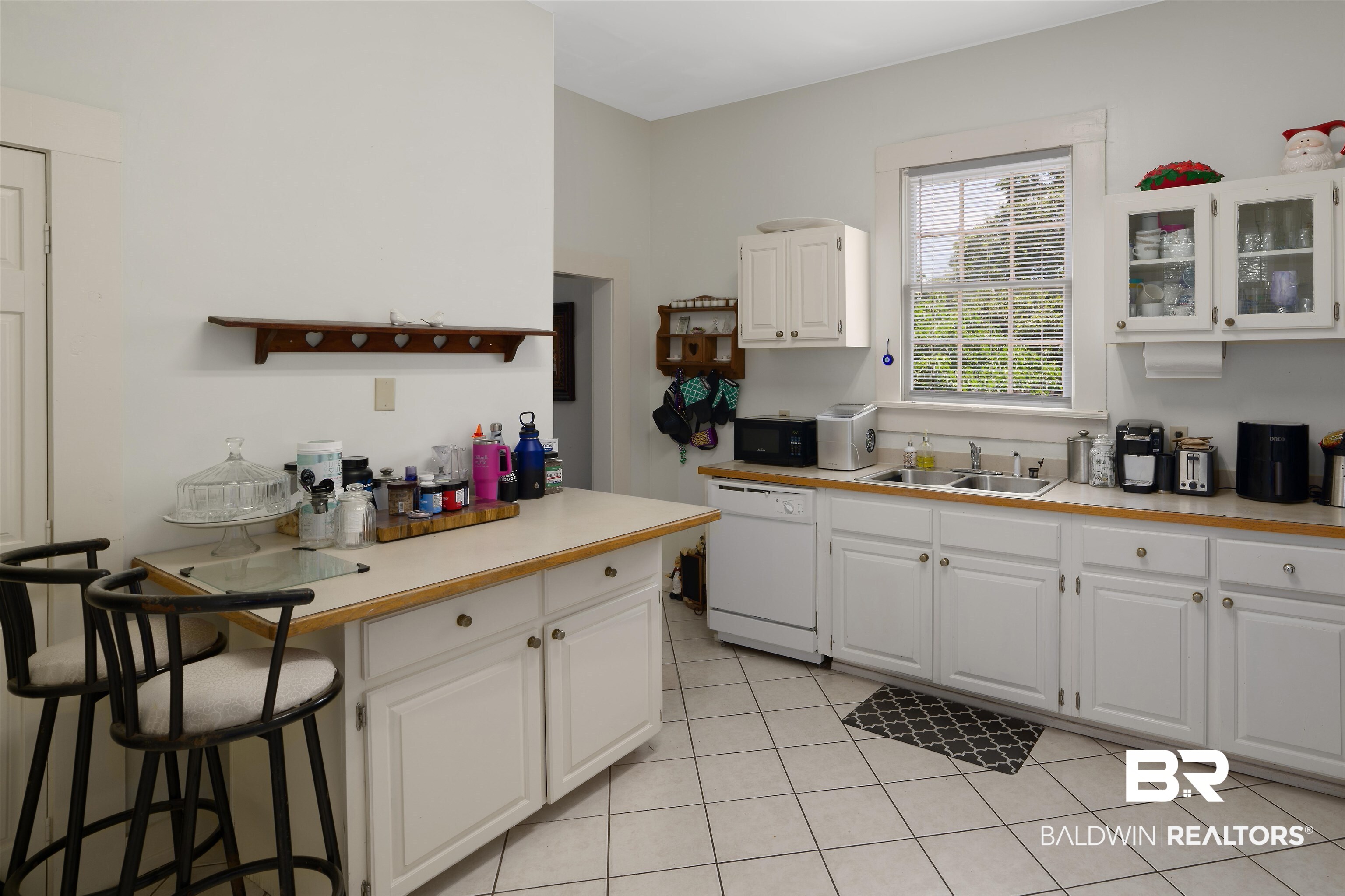 1010 Dauphin Street Mobile, AL 36604 - Photo 12 of 22 Kitchen with white cabinetry, light tile patterned flooring, dishwasher, and sink