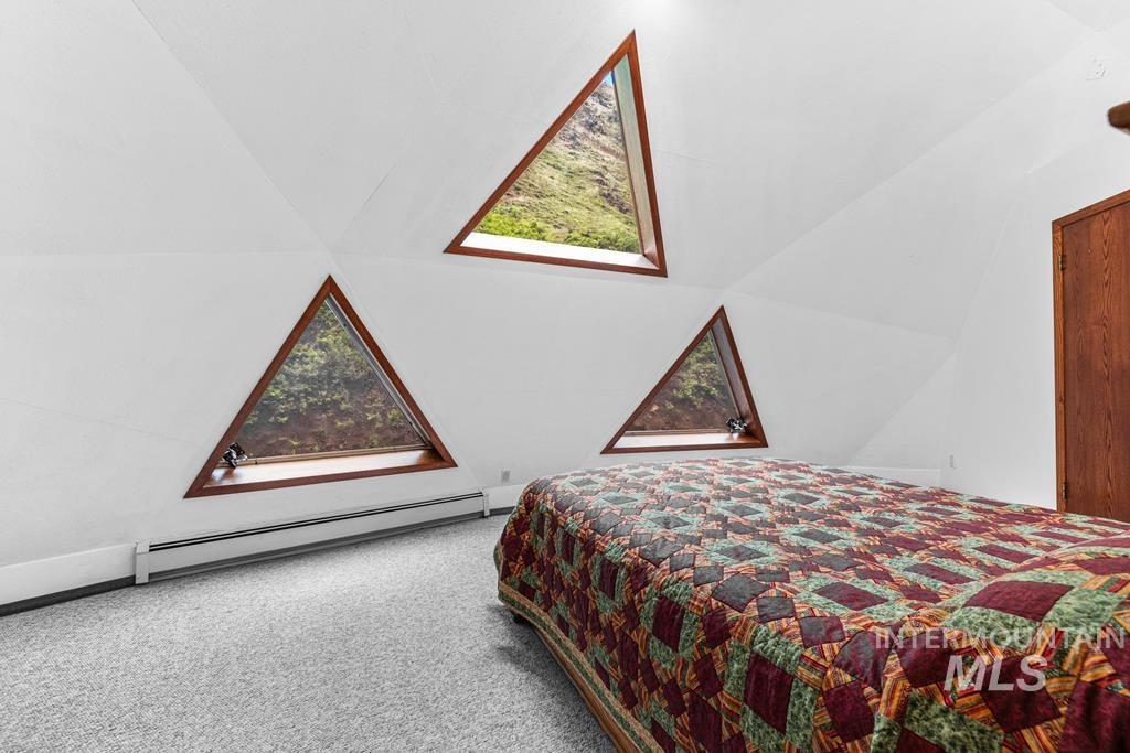 360 Lake Creek Riggins, ID 83549 - Photo 18 of 50 Carpeted bedroom with a baseboard heating unit and lofted ceiling