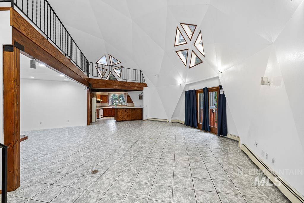 360 Lake Creek Riggins, ID 83549 - Photo 3 of 50 Unfurnished living room featuring a baseboard heating unit and a high ceiling
