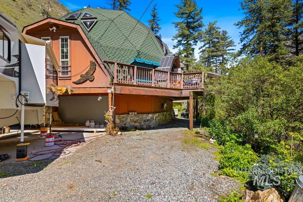 360 Lake Creek Riggins, ID 83549 - Photo 37 of 50 Rear view of house featuring a wooden deck, roof with shingles, and a gambrel roof
