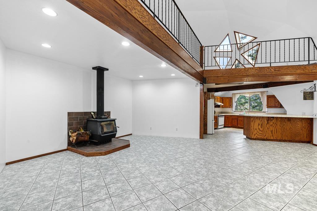 360 Lake Creek Riggins, ID 83549 - Photo 6 of 50 Unfurnished living room featuring a high ceiling, a wood stove, light tile patterned floors, and recessed lighting